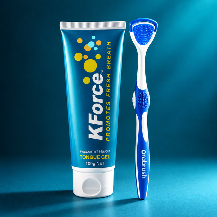 KForce Peppermint Flavor Tongue Gel 100g tube standing next to an Orbbrush manual tongue scraper on a dark blue gradient background.